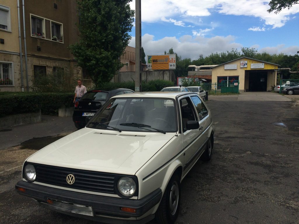 Szemből a fehér II-es Golf, ahonnan egyből szembe tűnik, hogy majdnem 30 éve még más méreteket jelentett az alsó-középkategória